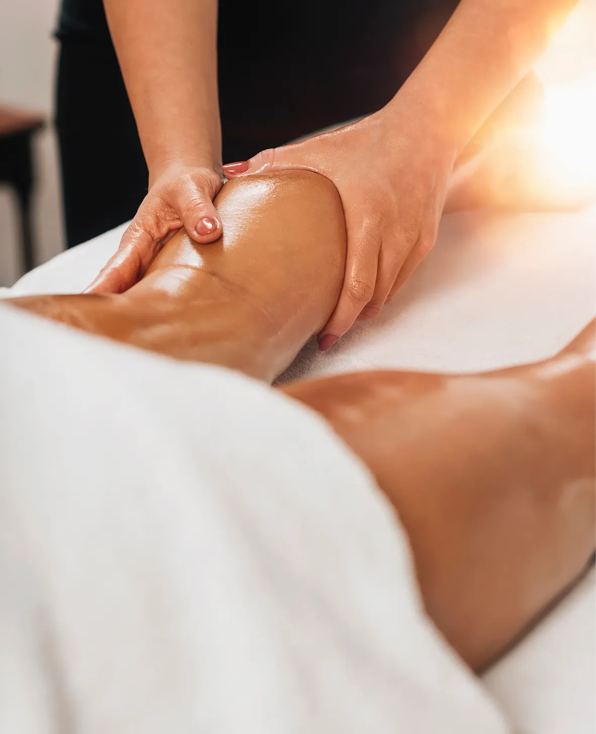 Une personne recevant un massage sur la jambe avec des mains appliquant une pression.